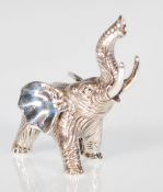 A silver figurine of an elephant with an extended
