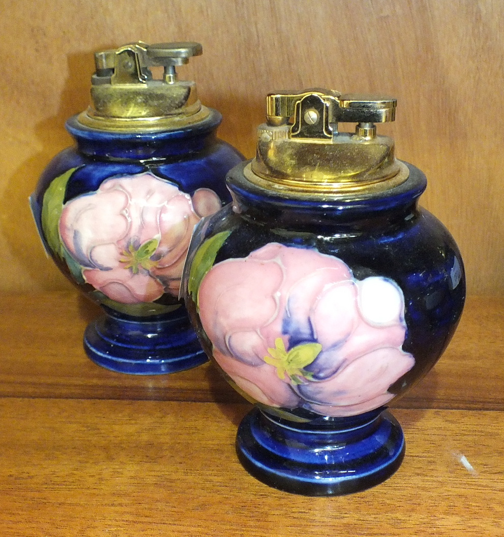 Two Moorcroft baluster-shaped blue-glazed table lighters decorated in the Magnolia pattern, 12cm