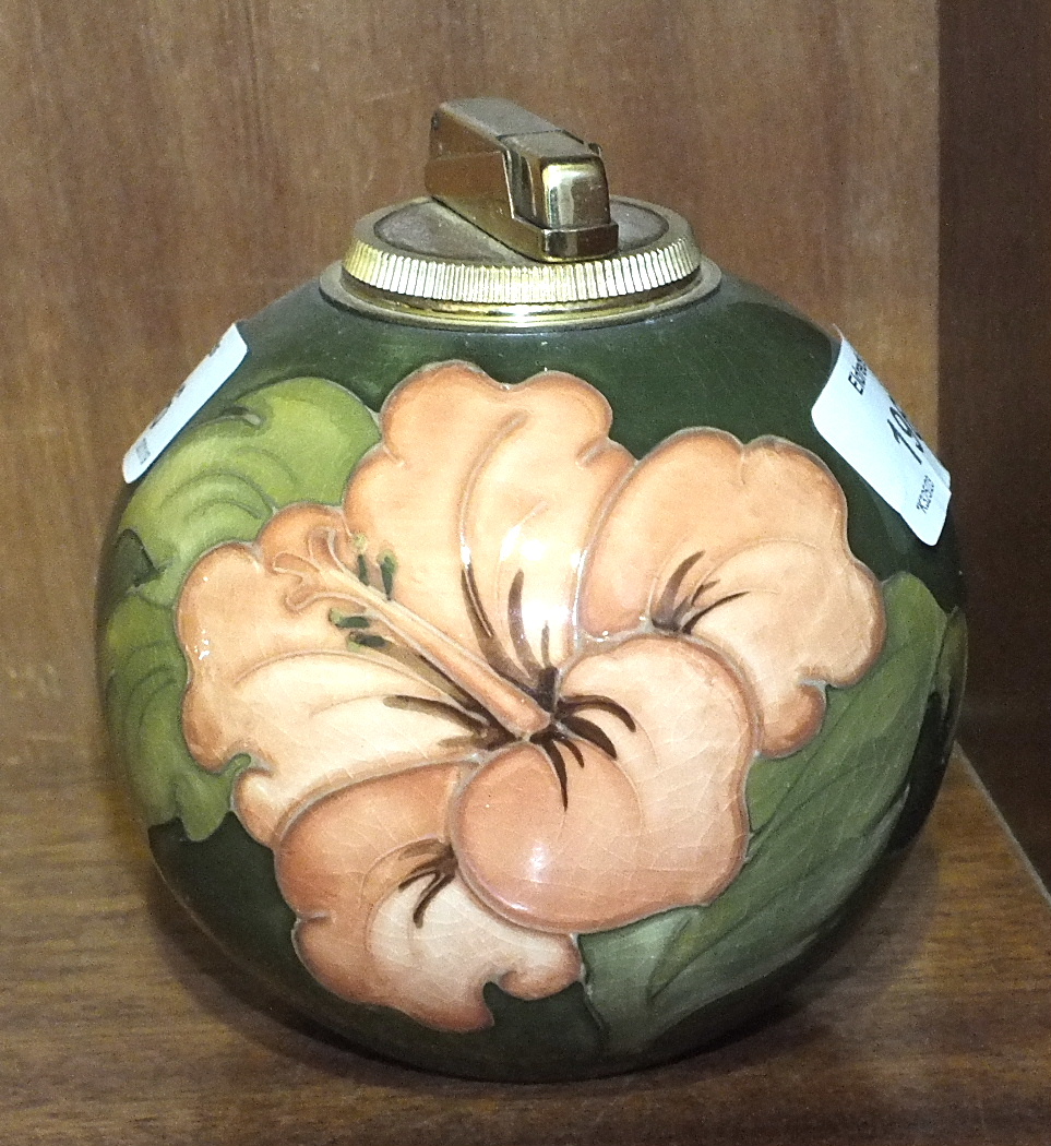 A Moorcroft ball-shaped green-glazed table lighter decorated in the Hibiscus pattern, paper label to