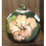 A Moorcroft ball-shaped green-glazed table lighter decorated in the Hibiscus pattern, paper label to