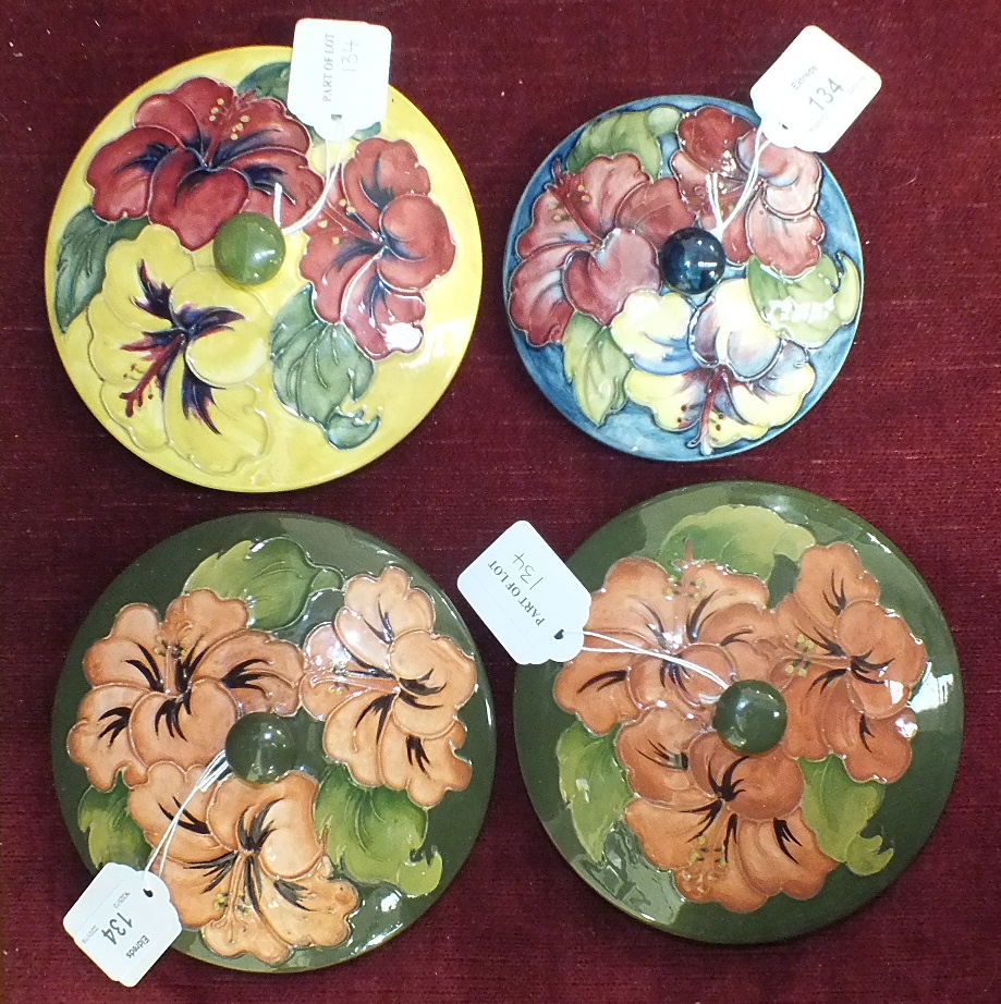 Two Moorcroft green-glazed circular pot lids decorated with hibiscus flowers, 14.5cm diameter,