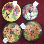 Two Moorcroft green-glazed circular pot lids decorated with hibiscus flowers, 14.5cm diameter,