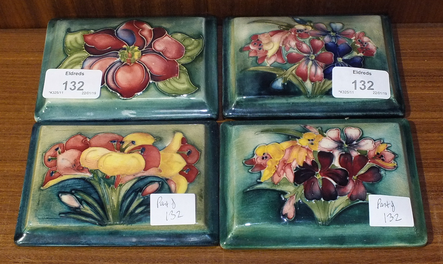 Four Moorcroft rectangular green/blue-glazed lids, 'African Lily', 'Clematis' and 'Spring