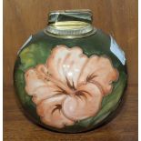 A Moorcroft ball-shaped green-glazed table lighter decorated in the Hibiscus pattern, paper label to