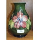 A Moorcroft baluster-shaped green-glazed vase decorated in the Hibiscus pattern, impressed