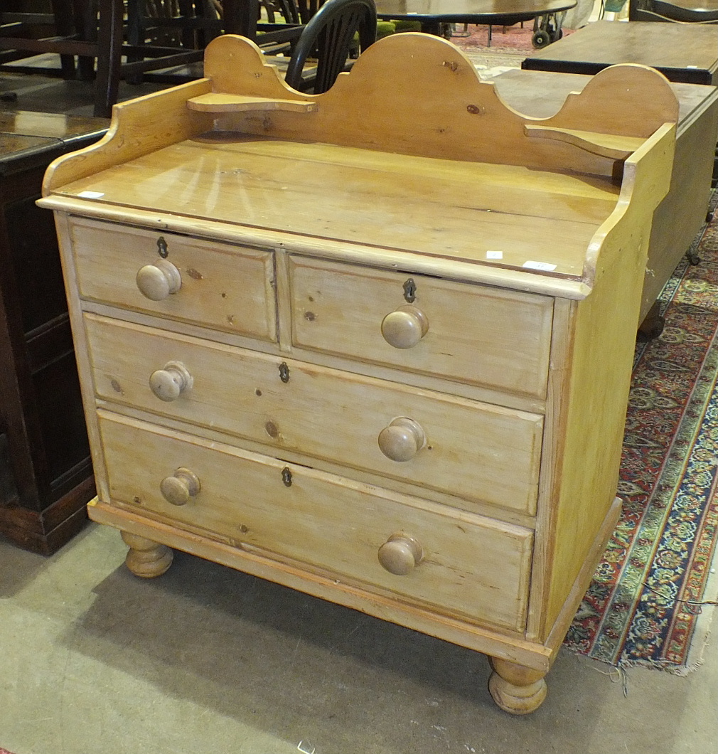A stripped pine wash stand, the rectangular tray top above two small and two long drawers, on turned