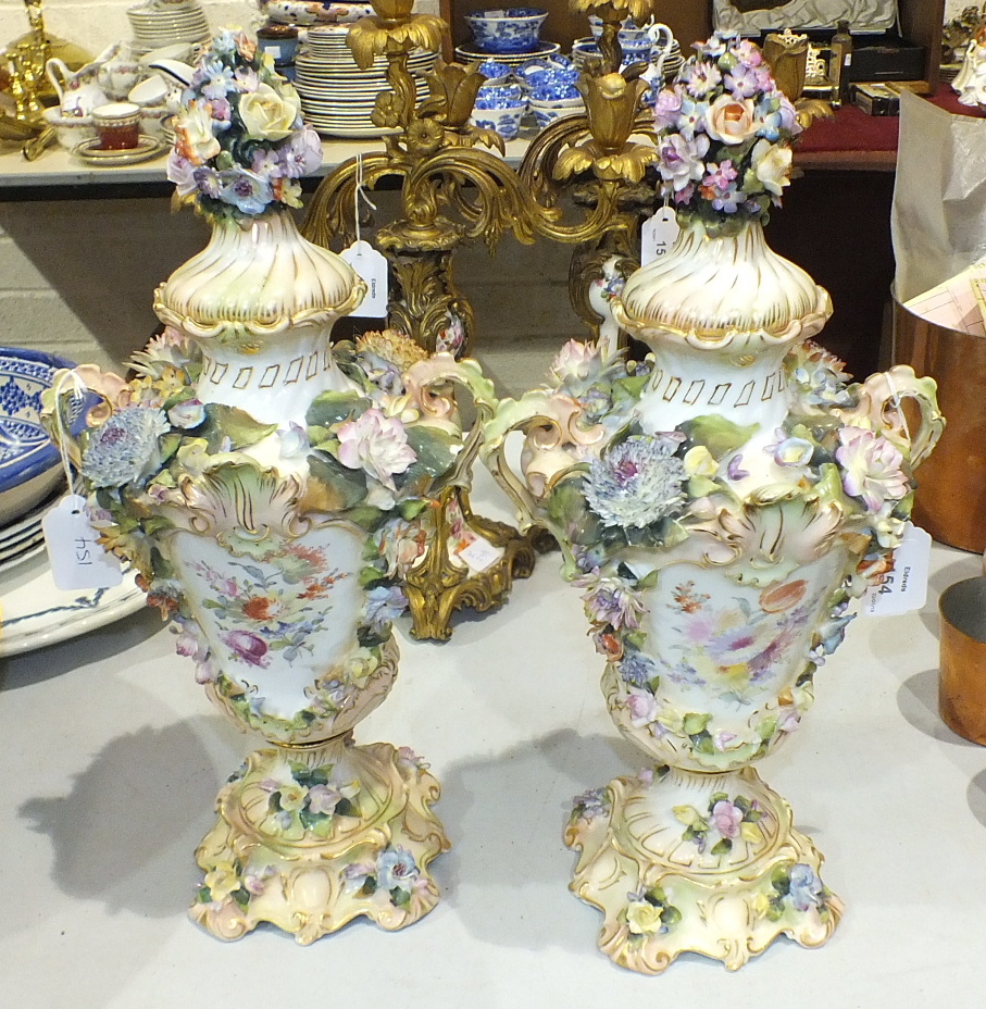 A pair of late-19th century Continental flower-encrusted vases and covers, 41cm high, (some