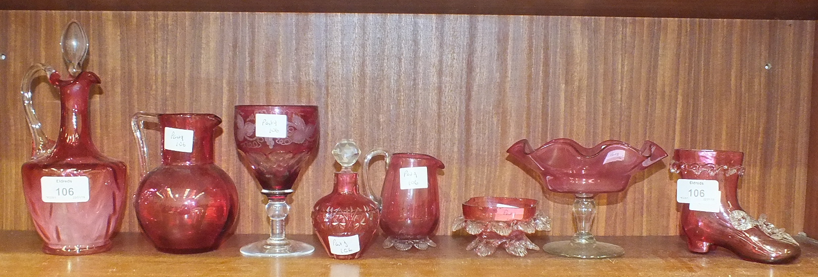 A cranberry glass jug with clear glass handle and stopper, 21cm high, a cranberry glass wine glass