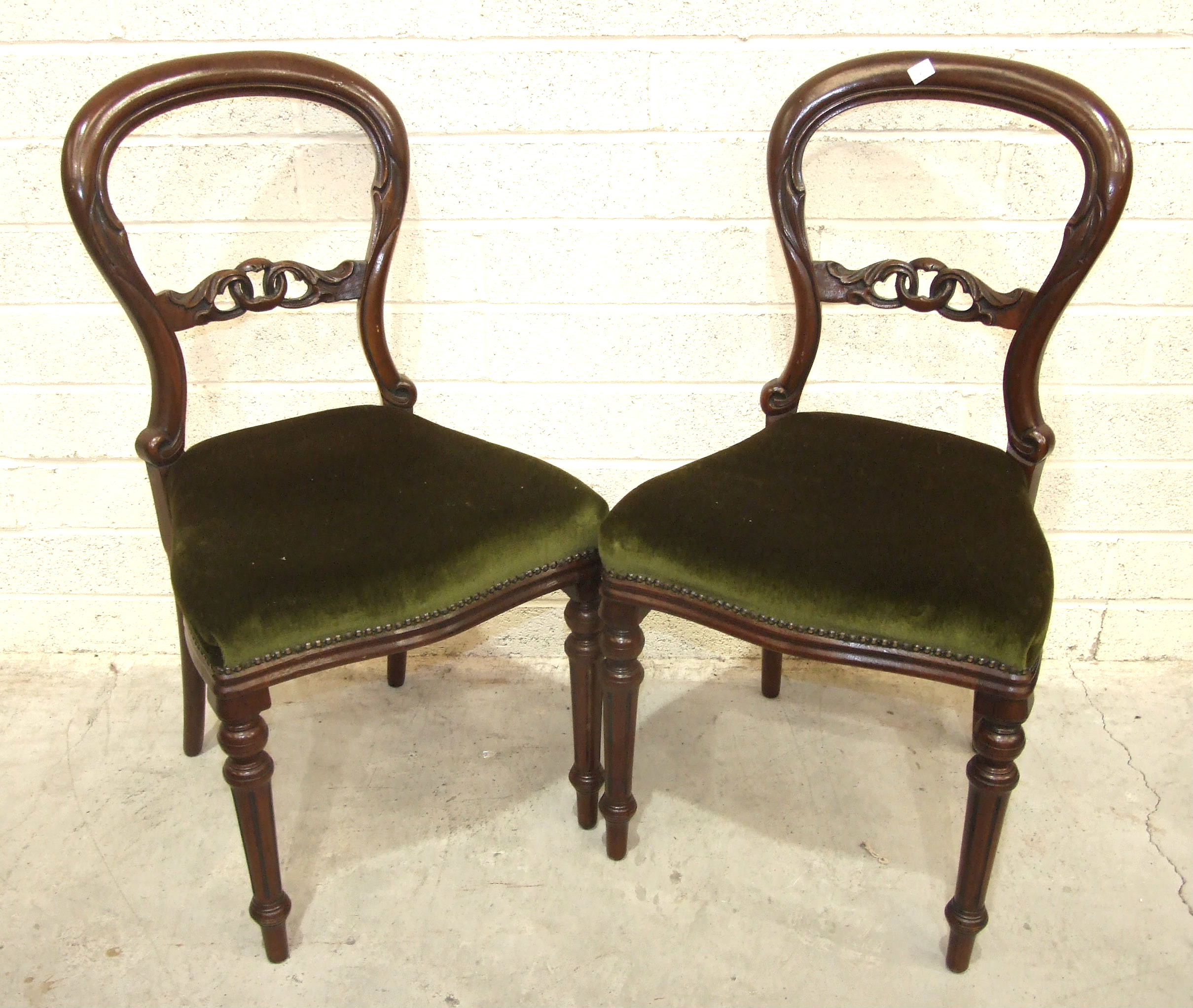 A set of eight Victorian-style balloon-back mahogany dining chairs with serpentine seats, on