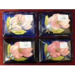 Four Moorcroft rectangular blue-glazed lids, each decorated with magnolia flowers, 12.5 x 9cm, (4).