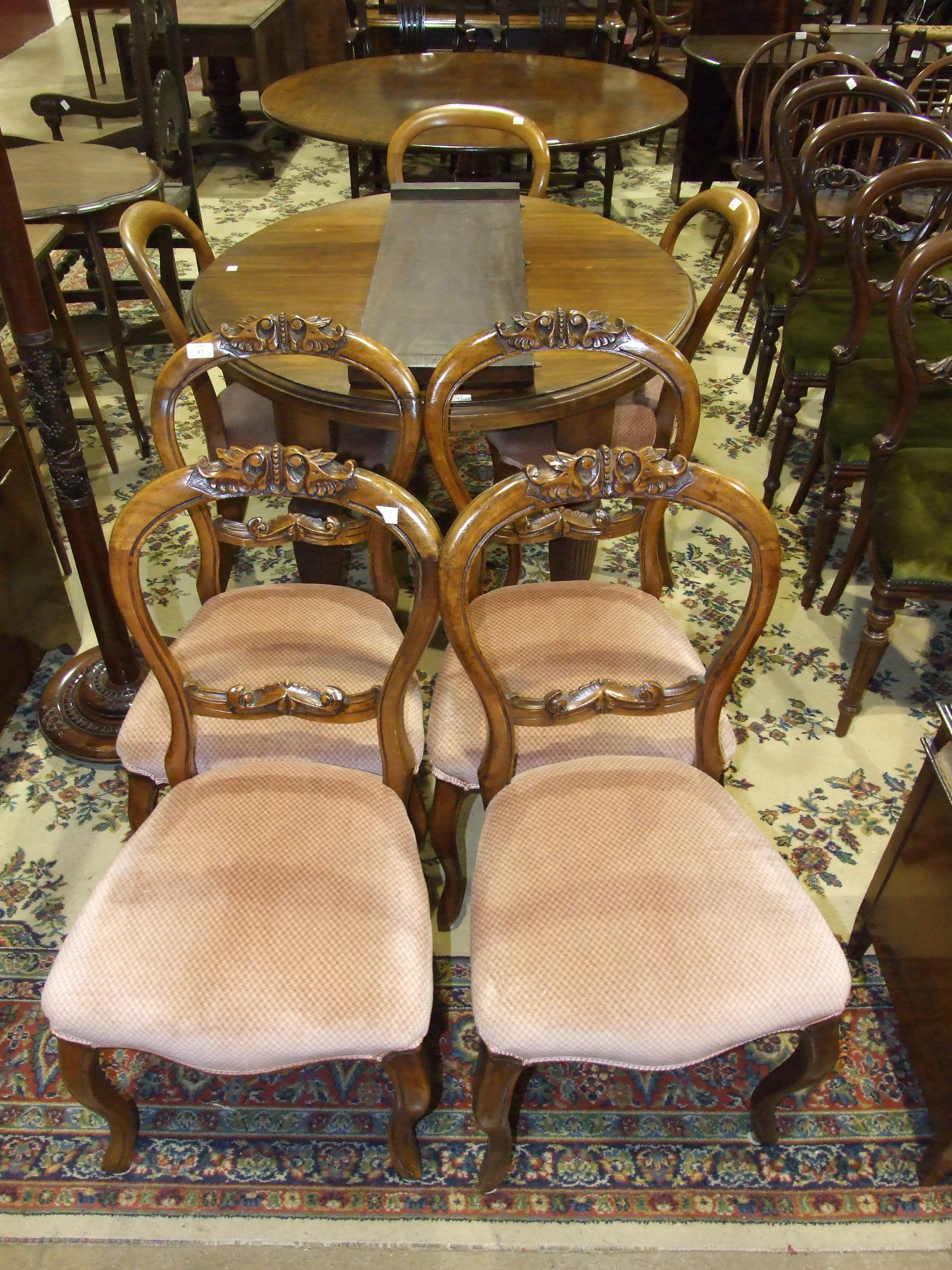 A set of four Victorian carved balloon-back dining chairs, three other similar chairs and a mahogany