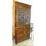 An antique oak and mahogany corner cupboard, having a pair of astragal-glazed doors, above a pair of