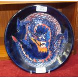 A Moorcroft plate decorated with a dragon on a deep blue ground, impressed Moorcroft, Made in