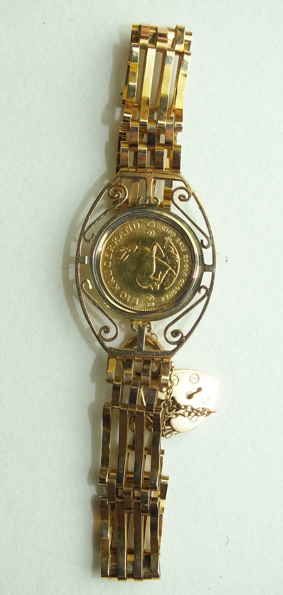 A 1/10 Krugerrand 1980 in a 9ct gold gate-link bracelet, 11.8g.