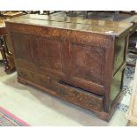 An antique oak narrow mule chest, the hinged lid above a panel front and two drawers, (reduced