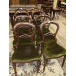 A set of eight Victorian-style balloon-back mahogany dining chairs with serpentine seats.