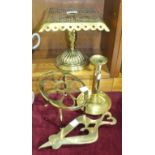 A brass trivet with pierced square top, 21.5cm high, two other trivets and a candlestick, (4).