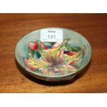 A Moorcroft green-glazed small bowl with tiger lily decoration, on green ground, impressed factory