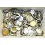 A large quantity of pocket watch movements, metal cases, and other pocket watch parts.