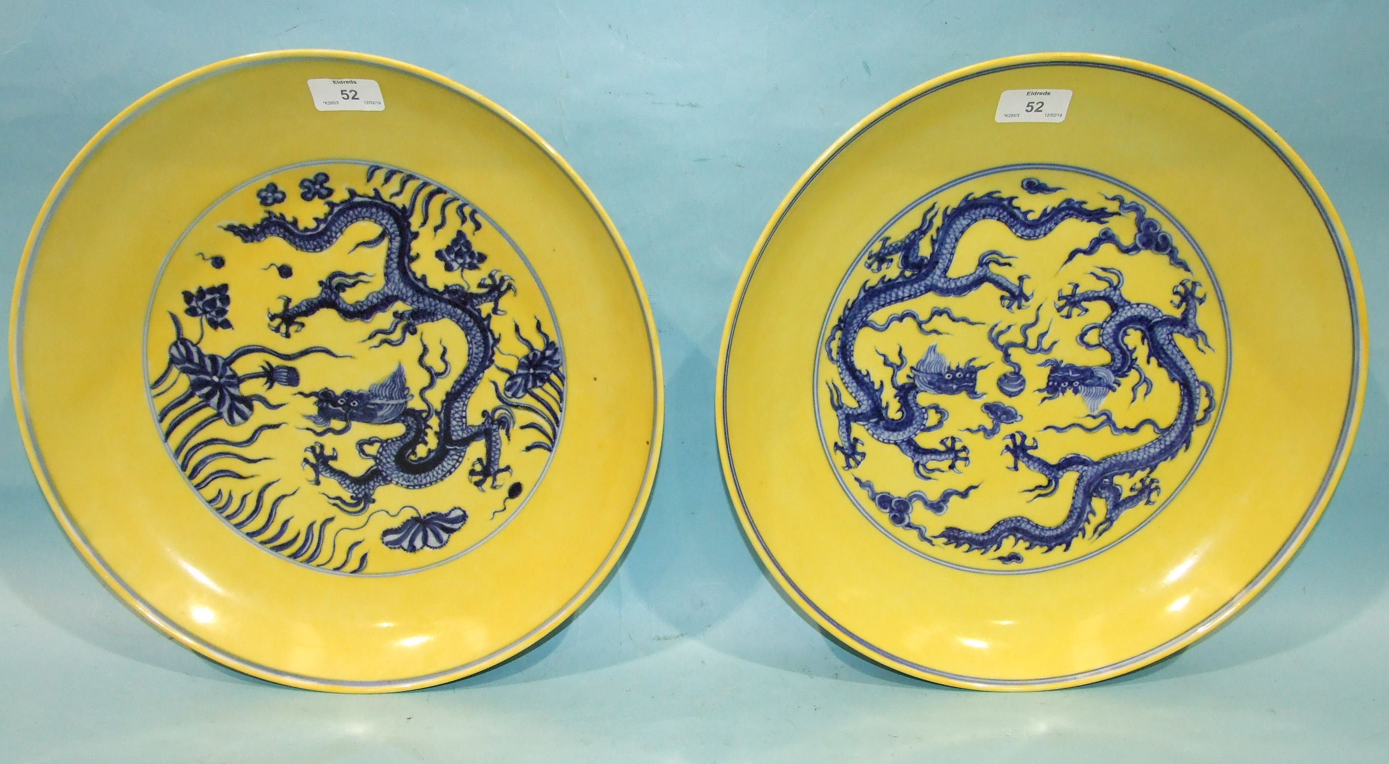 Two similarly-decorated yellow and blue dragon dishes, in Ming style, 36cm diameter, (2).