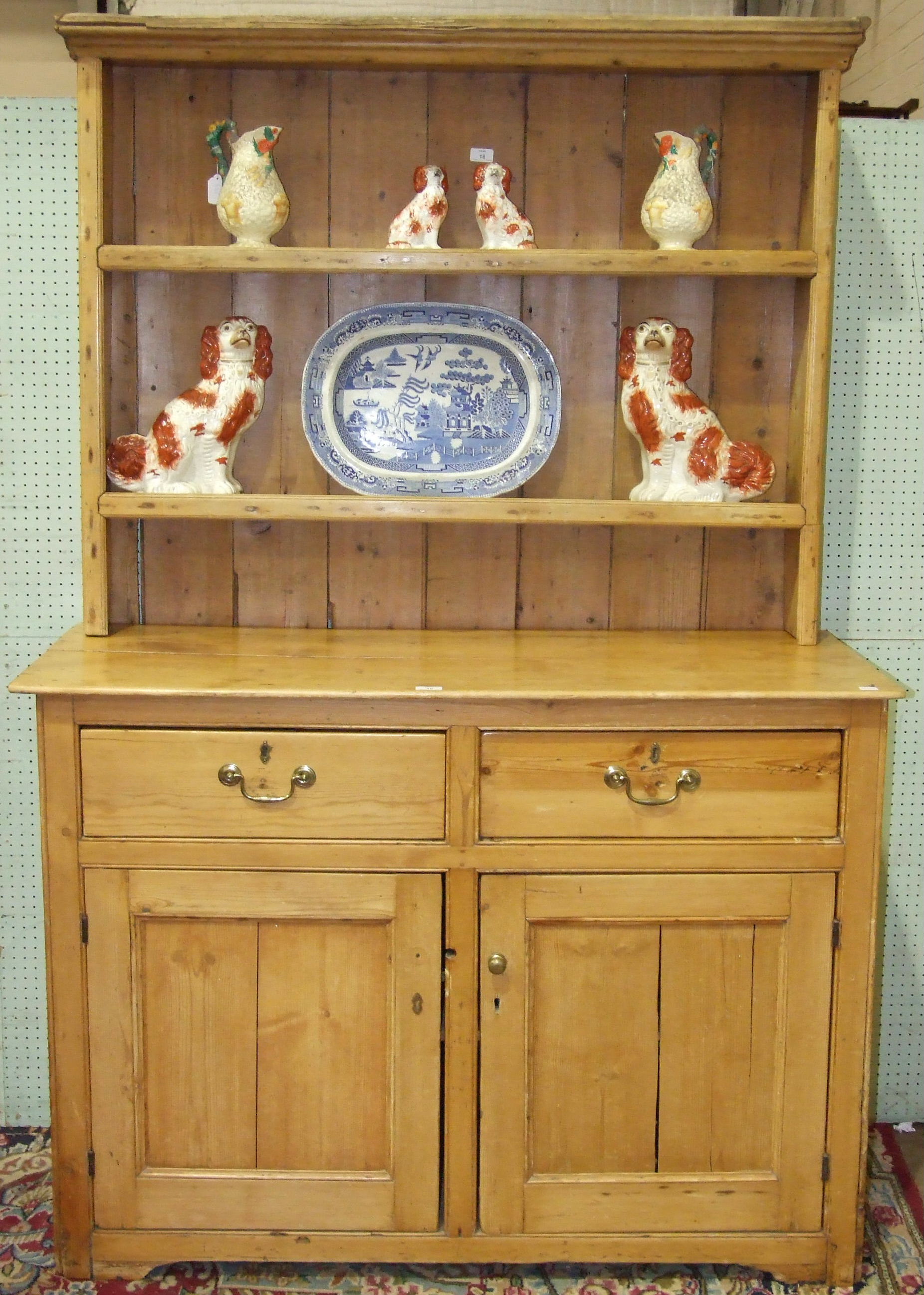 A pine dresser, the shelved top above two drawers and two cupboard doors, 130cm wide, 195cm high.