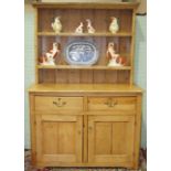 A pine dresser, the shelved top above two drawers and two cupboard doors, 130cm wide, 195cm high.