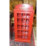 A red painted wine rack in the form of a telephone box, fitted with a glazed door and four bottle