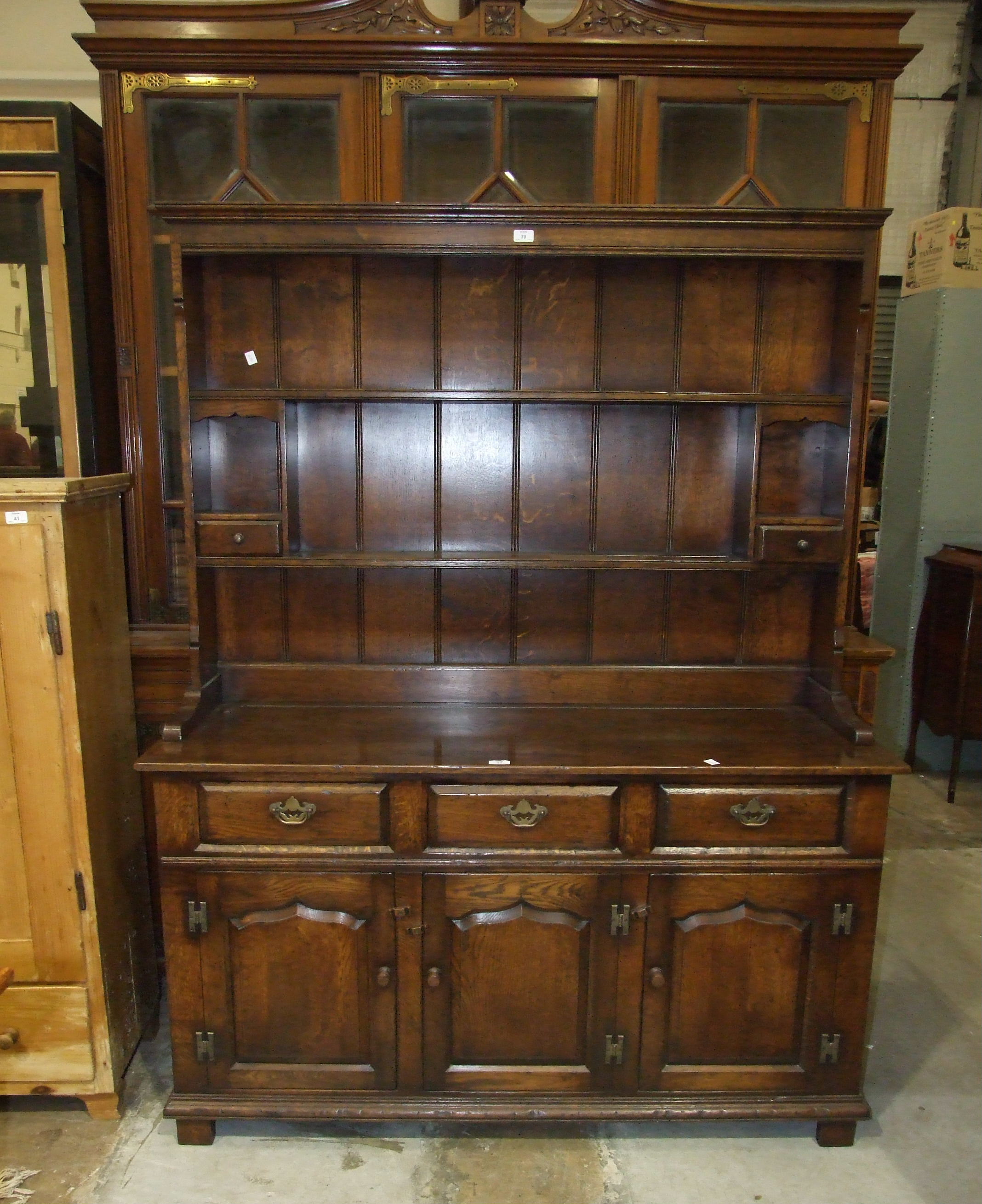 A reproduction oak dresser, the plate rack above an arrangement of drawers and cupboard doors, 142.