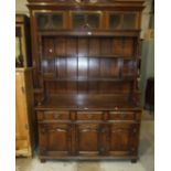 A reproduction oak dresser, the plate rack above an arrangement of drawers and cupboard doors, 142.