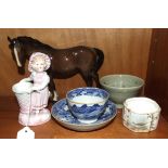 A blue and white tea bowl and saucer decorated with a building in a landscape and other ceramics.