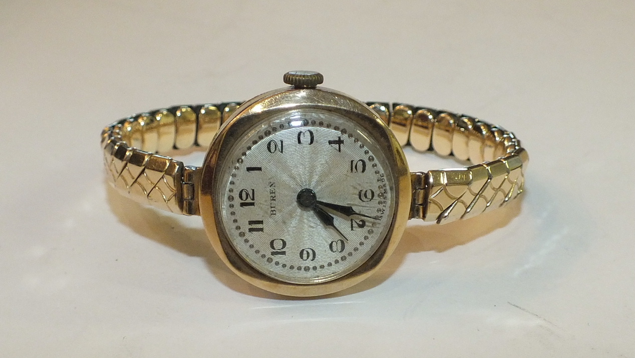 A ladies 9ct-gold-cased wrist watch by Buren, on plated expanding bracelet.