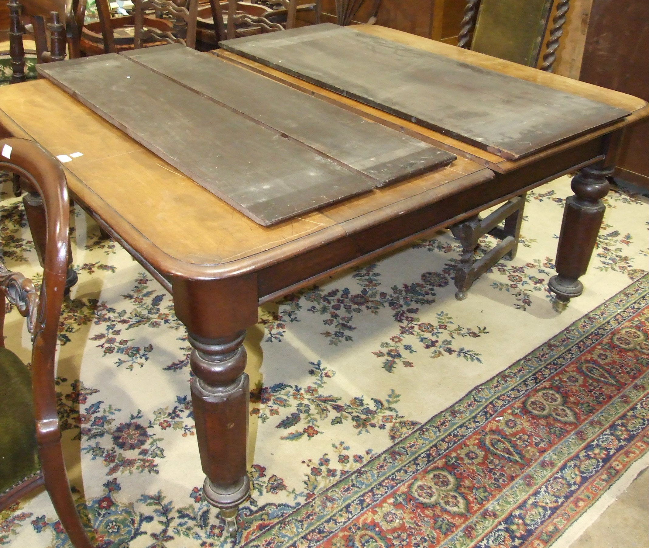 A 19th century mahogany pull-out dining table, the top with three spare leaves, on octagonal and