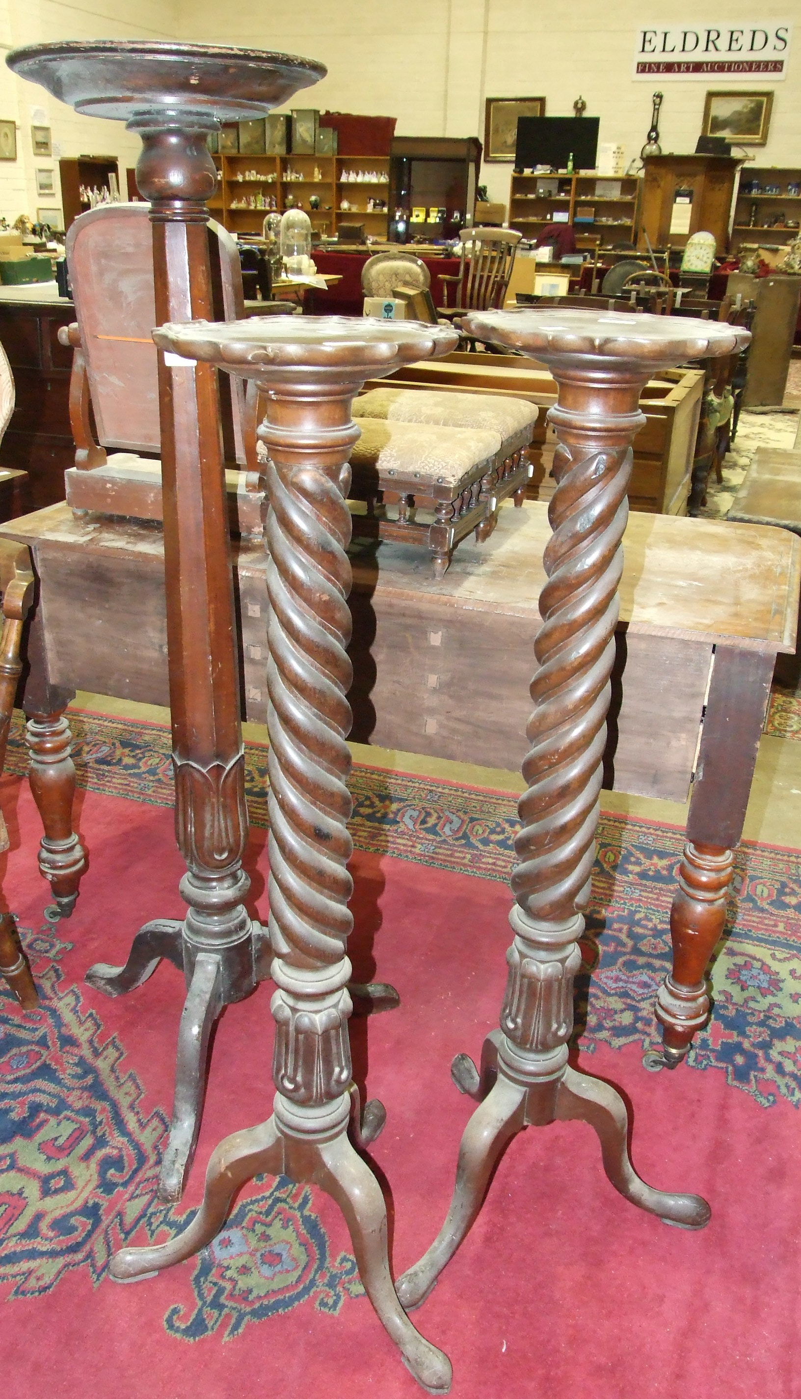 A pair of mahogany torchères, each with twist and carved column, on cabriole tripod support, 118cm