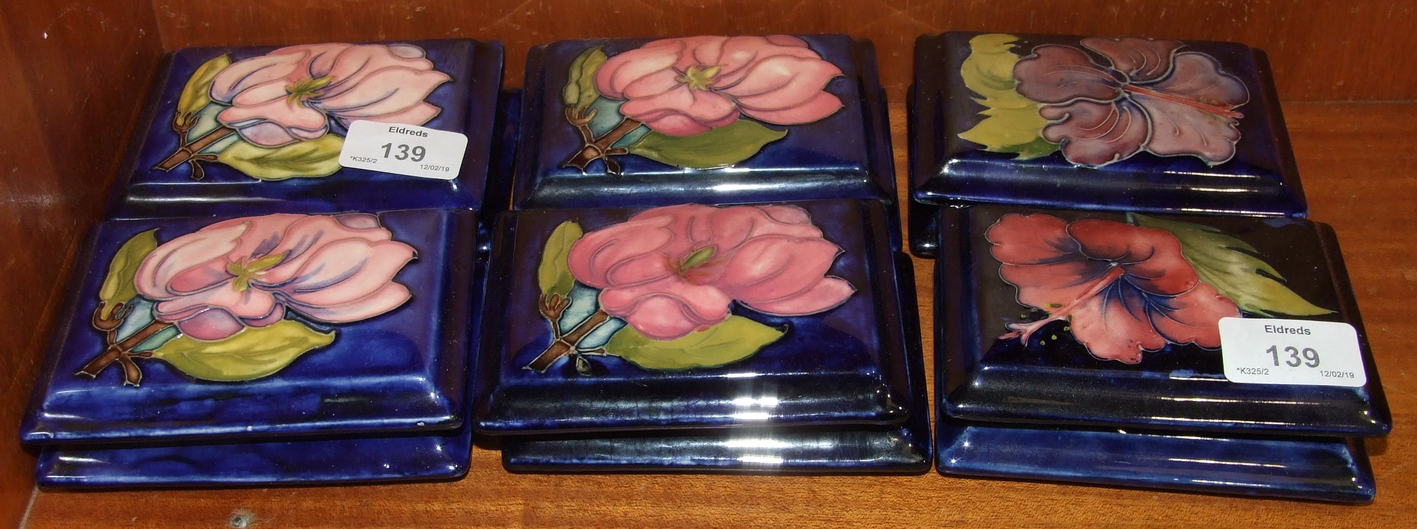 A collection of twelve Moorcroft rectangular blue-glazed lids, each 12.5 x 9cm, eight decorated with