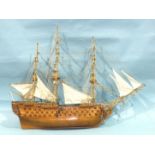 A modern kit-built model of a three-masted four-deck warship, with brass cannon and metal anchors,