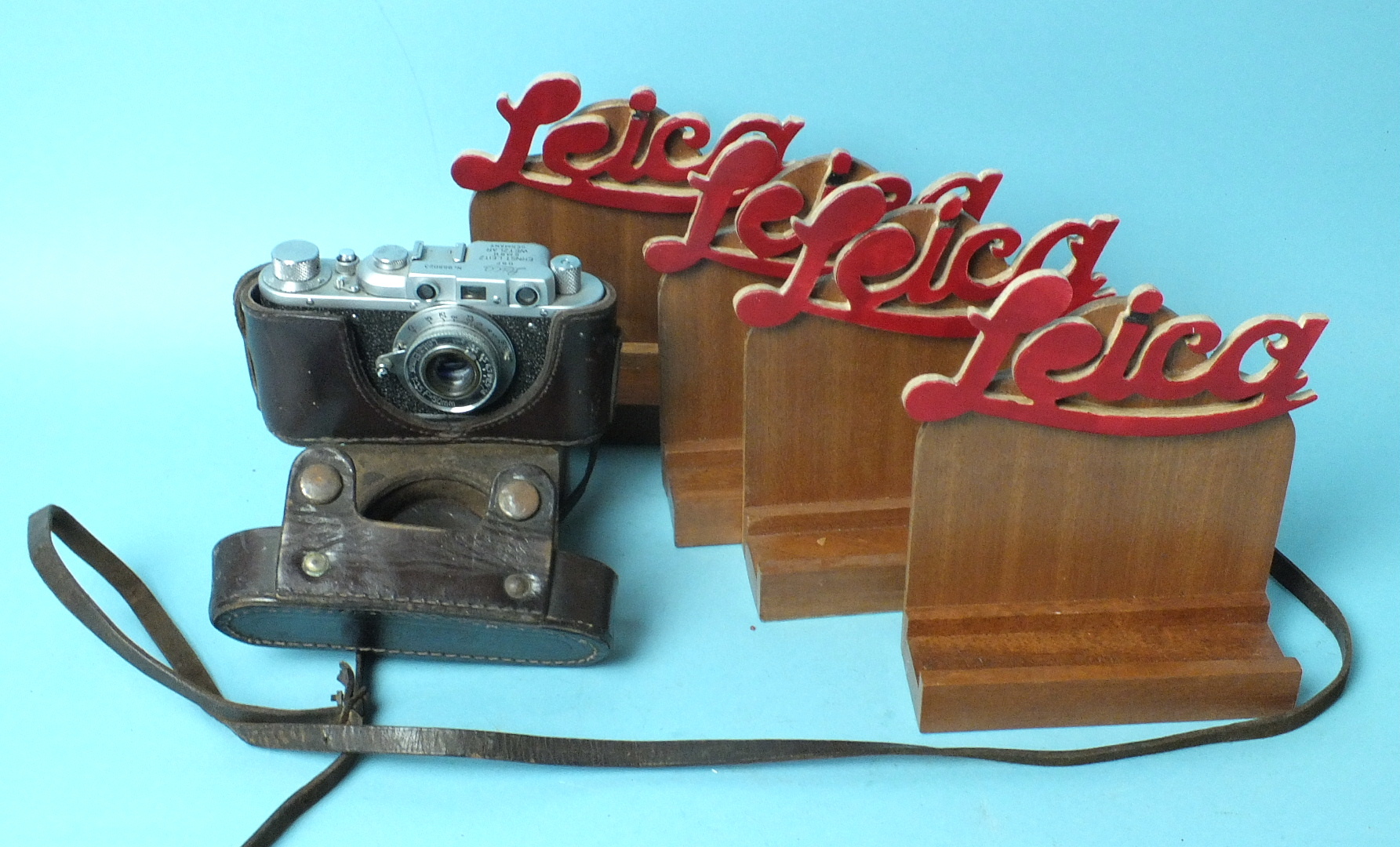 A Russian copy of a Leica II camera and four wooden "Leica" display stands.