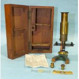 A small brass microscope, 17.5cm high, with accessories, in mahogany case.