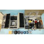 A Canon Tele Converter TC-DC58A 1.5x and other camera filters and accessories, in two metal cases.