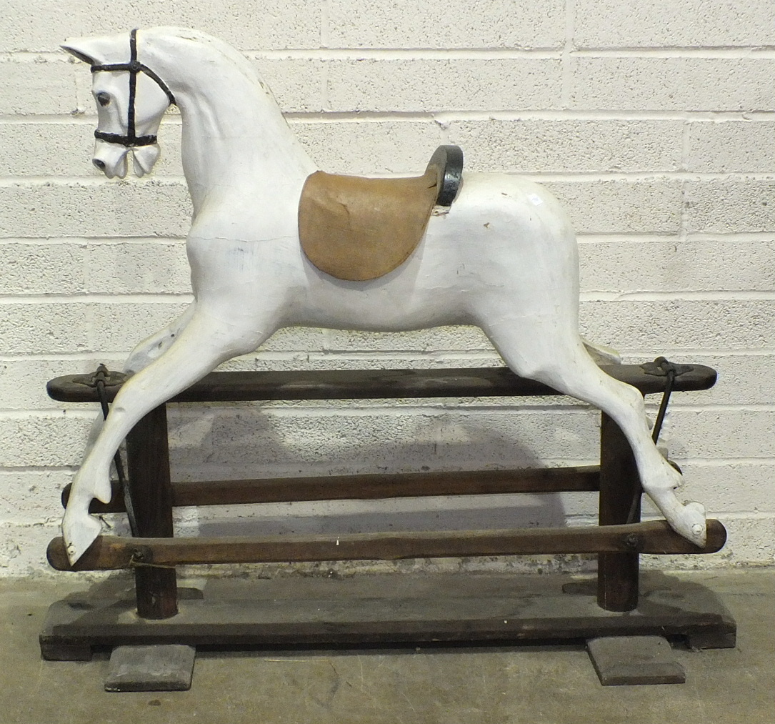 An early-20th century rocking horse on pine trestle, (a/f, re-painted, no mane or tail), 110cm high,