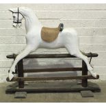 An early-20th century rocking horse on pine trestle, (a/f, re-painted, no mane or tail), 110cm high,