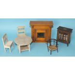 A collection of Edwardian doll's house furniture, including a wooden fire place with turned pillars,