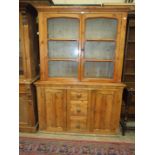 A stained pine dresser, the shelved top fitted with a pair of glazed doors, above three small