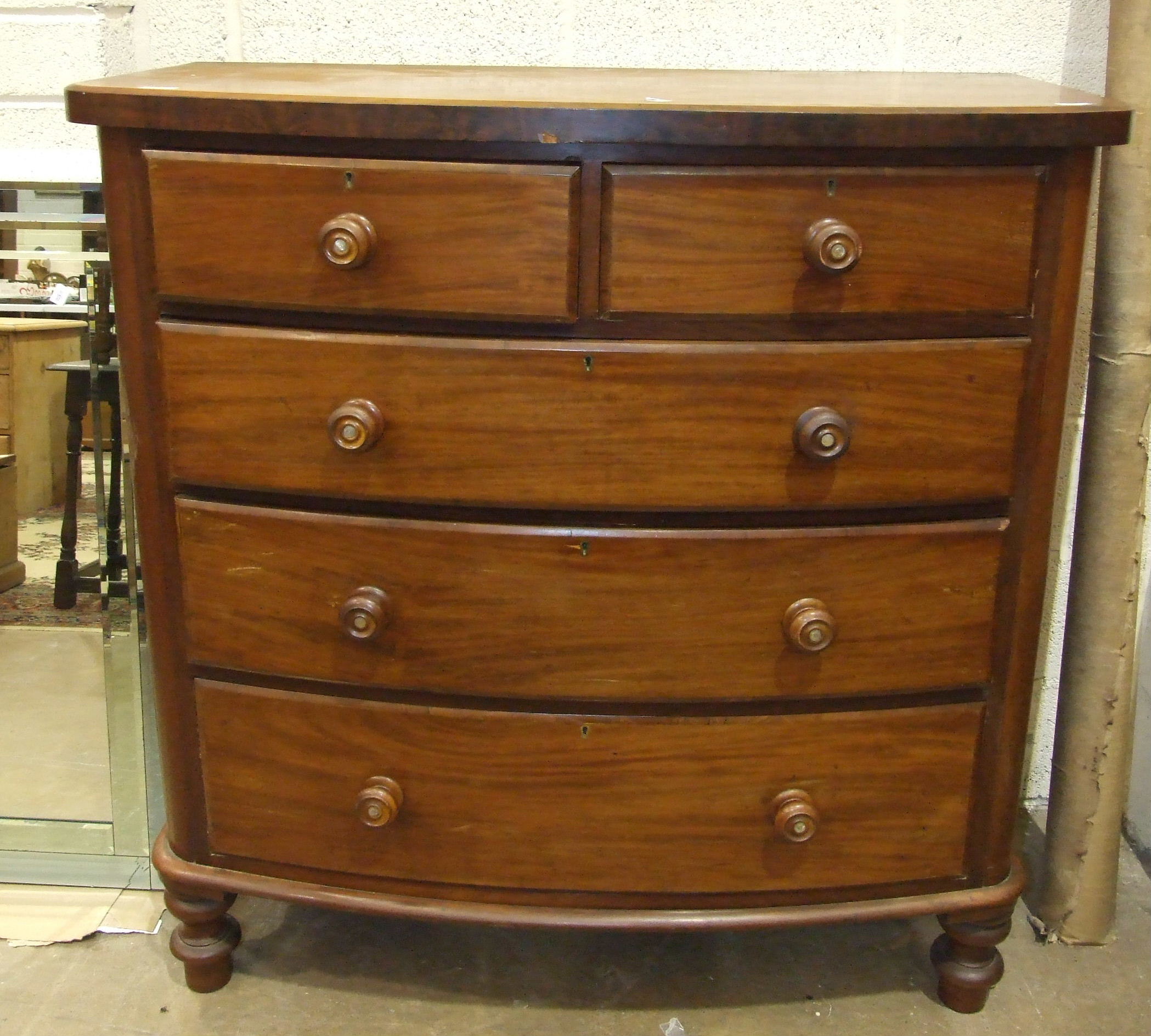 A late-19th century mahogany bow-fronted chest of two short and three long drawers, on turned