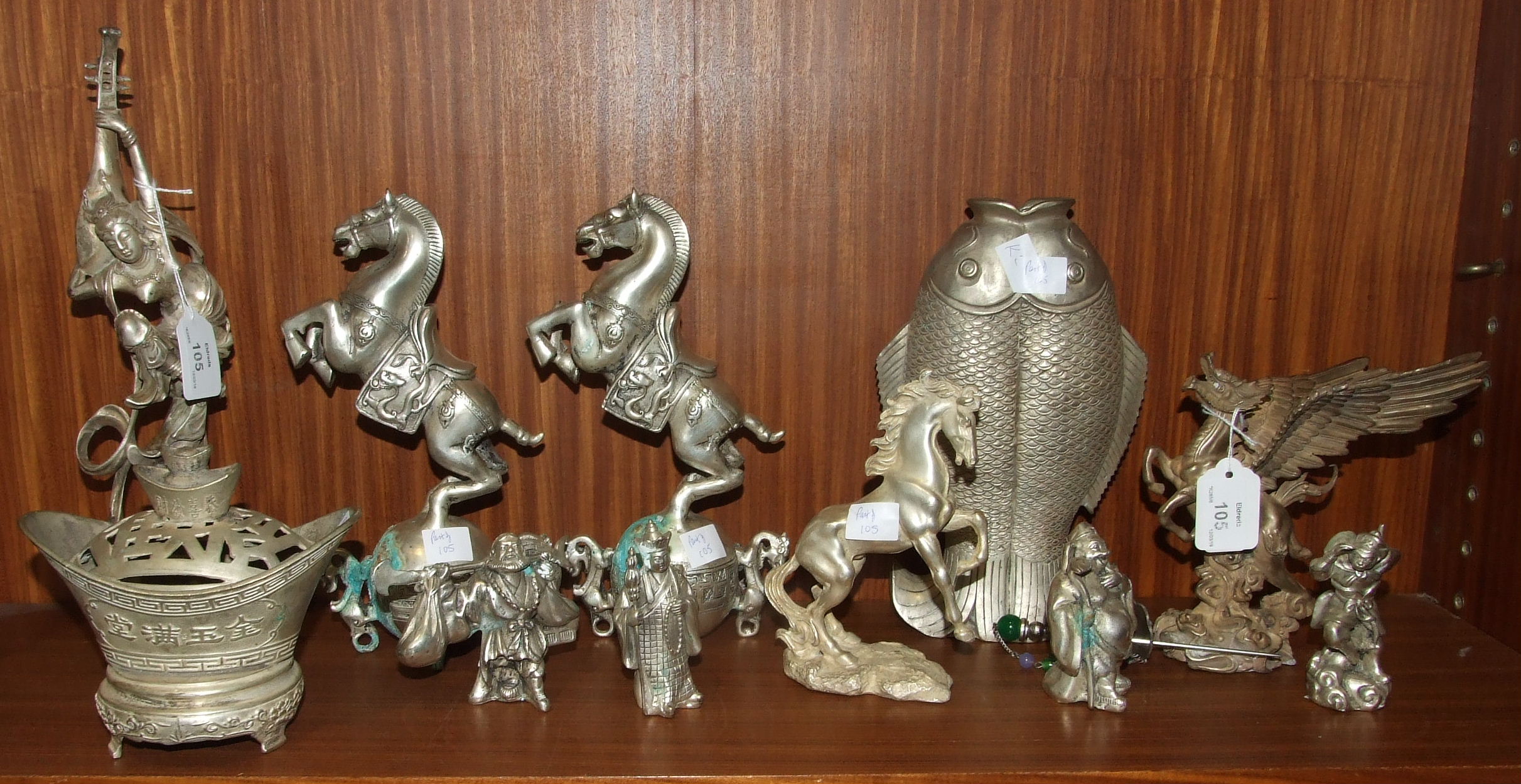 A collection of eleven reproduction Oriental metal figures of deities, animals, etc.