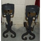 A pair of wrought metal andirons, each with a cresset above scroll supports, 52cm high, (2).