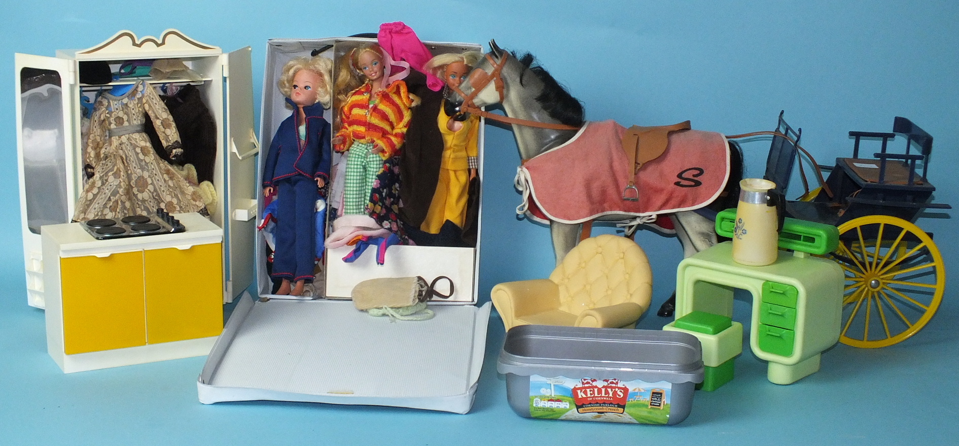 A Sindy doll, two others, similar, a Sindy horse with harness and buggy, wardrobe and clothes, oven,