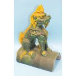 A Chinese ridge tile in the form of a dog, in ochre and green-glazed colours, 37cm high.