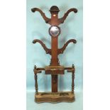 A Victorian mahogany four-branch hall stand, with central circular mirror above a glove box and