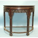 A late 19th century Chinese carved hardwood half-round side table, the top with moulded edge above a