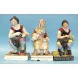 Three 19th century square-based figures of two cobblers and wife, 17cm and 16cm high, (3).